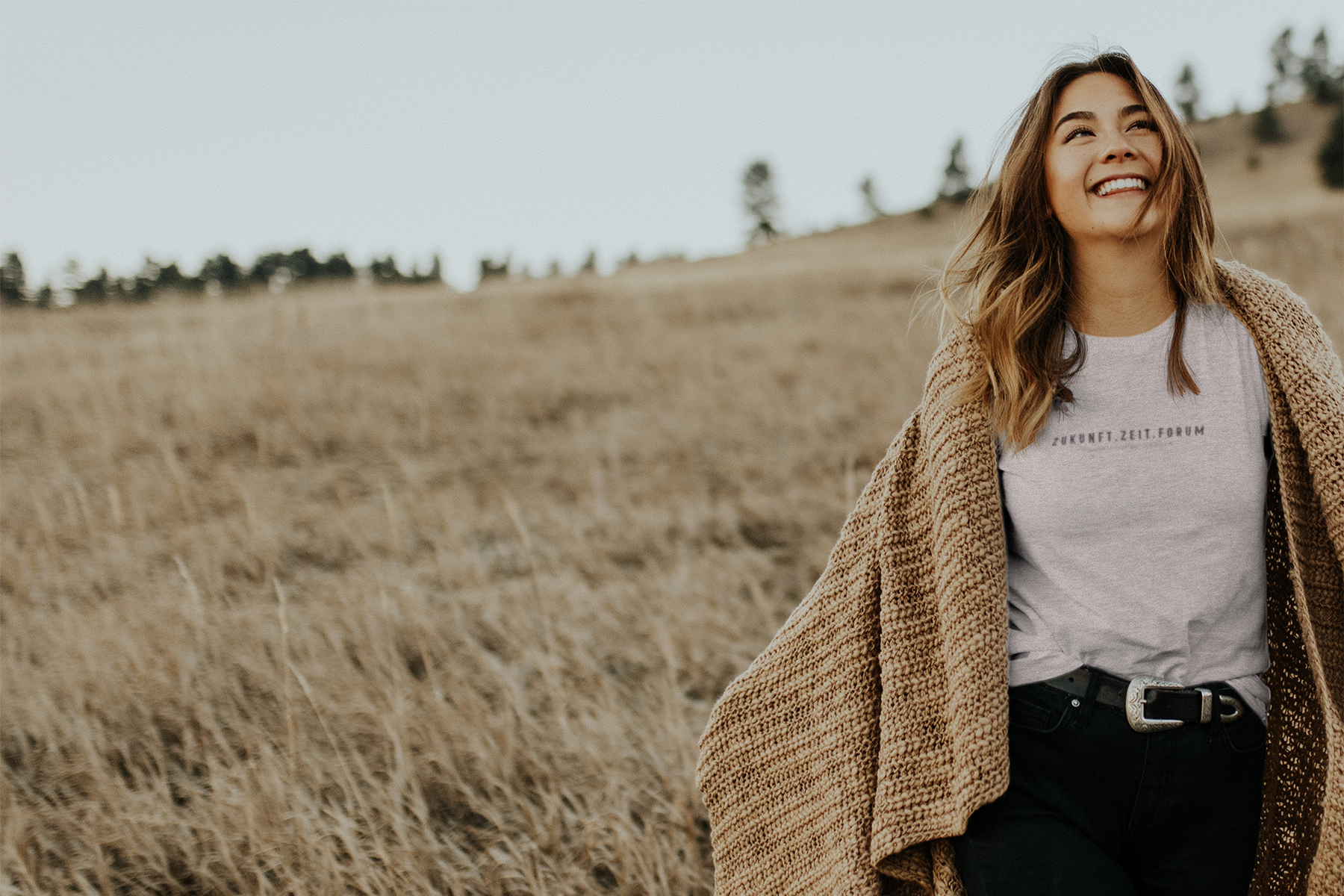 Frau in einem Feld mit ZUKUNFT.ZEIT.FORUM T-Shirt
